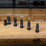 Set of six black woodworking dust hose adapters with labeled diameters on a workbench.