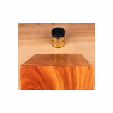 Wood oil finish jar on workbench behind polished wooden block, woodworking supplies