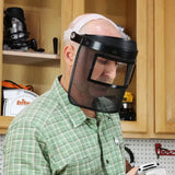 Woodworker wearing a mesh face shield for safety in a workshop setting