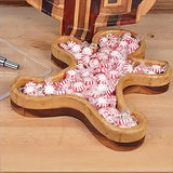 Wooden gingerbread man tray filled with peppermint candies on a workbench