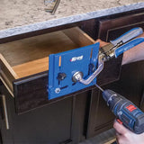 Drawer front being installed with a Kreg jig and a cordless drill on dark kitchen cabinetry