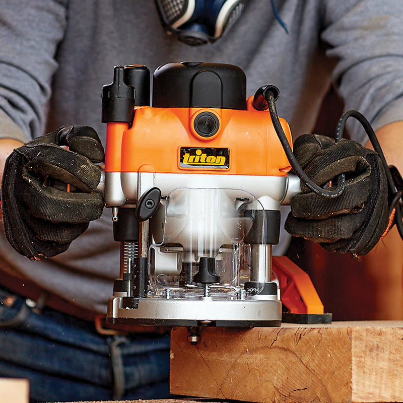 Plunge router in use on wood with gloved hands, woodworking power tool action