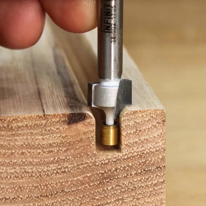 Router bit cutting a decorative groove in a wooden board, close-up woodworking tool.