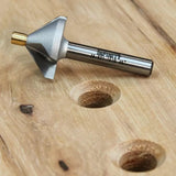 Chamfer router bit for woodworking placed on drilled wooden board