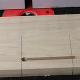 Woodworking mortise slot cut in light wood using a router table, close-up view.