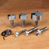 Set of precision woodworking router bits and bearings on wooden surface