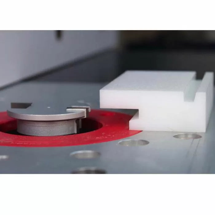 Router table setup with a slot cutter bit and a plastic test piece for woodworking joinery