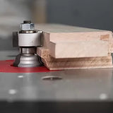 Woodworking router bit shaping wood edge on a router table in workshop setting