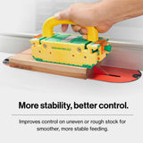 A hand operating a push block at a table saw.