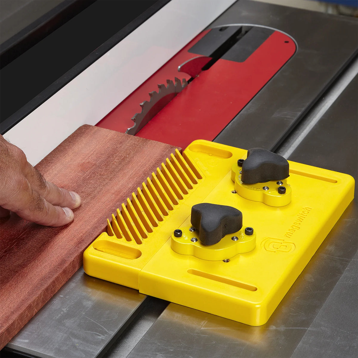 Table saw featherboard holding wood against fence for safe, precise woodworking cut