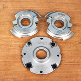 Three precision woodworking cutter heads for joinery on a wooden surface