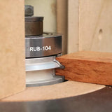 Carbide router bit cutting profile into hardwood on a woodworking router table