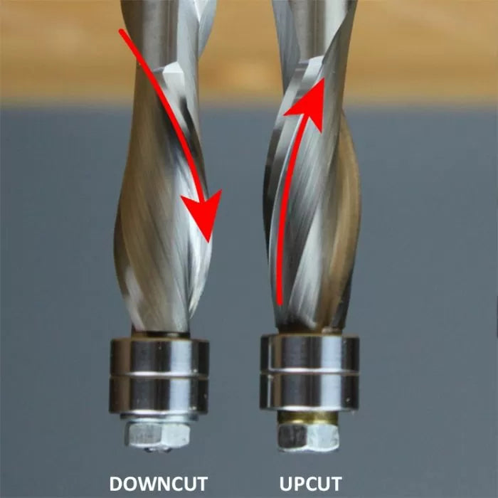 Close-up comparison of downcut and upcut spiral router bits with red arrows showing cutting direction