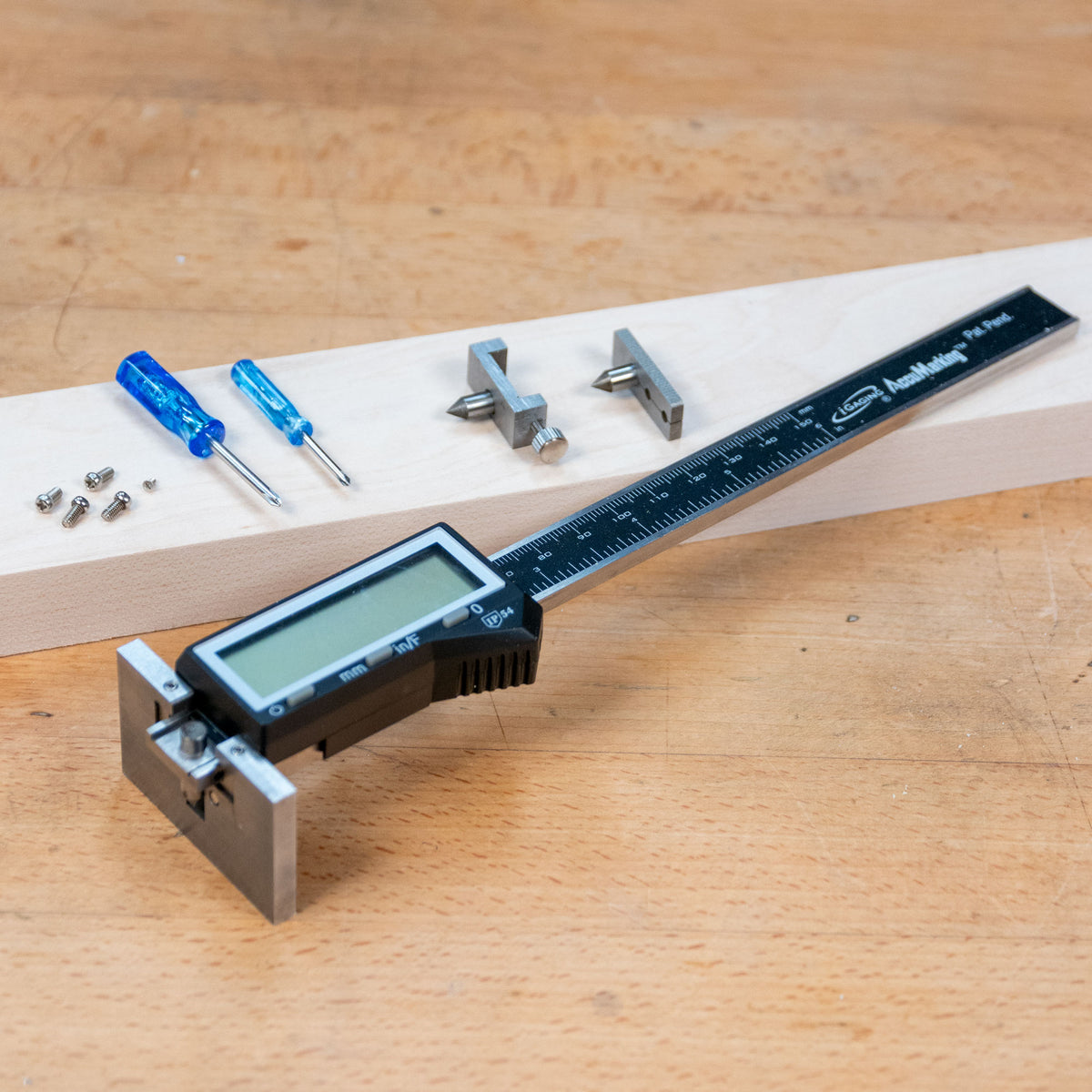 Digital marking and mortise gauge with ruler, parts, and screwdrivers on wood surface