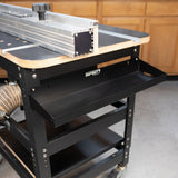 Router table tool tray mounted to a router table sitting on a concrete floor.