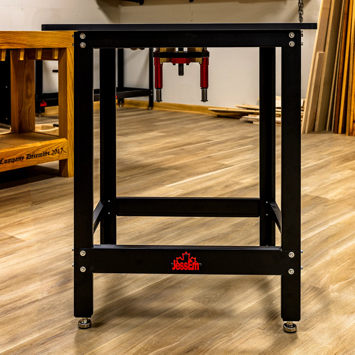 Heavy-duty router table stand with JessEm logo in a woodworking shop setting