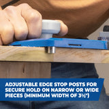 Hand using a woodworking jig with adjustable edge stop posts on a wooden board
