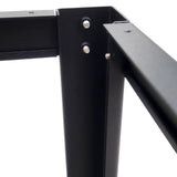 Close-up of black metal woodworking table frame corner with screws and joints