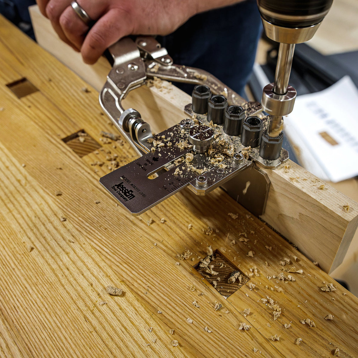Woodworker using a drill and dowel jig on a benchtop for precision woodworking joinery
