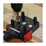 Drill guide dowel jig clamped to wood with a drill for woodworking joints