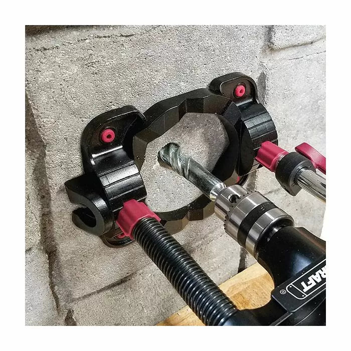 Drill guide jig clamped to concrete wall with drill bit for precise hole drilling