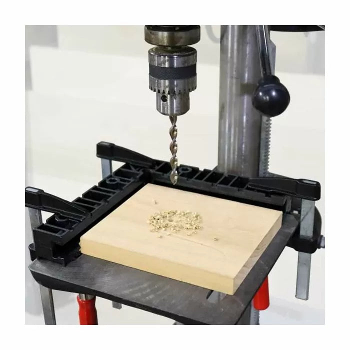 Drill press with wood drilling jig and clamped wood block for precise woodworking