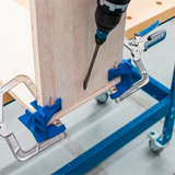 Pocket hole drilling jig clamps holding wood panels for precise woodworking joinery