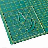 Acrylic compass rose template on a green gridded cutting mat for woodworking or crafts.