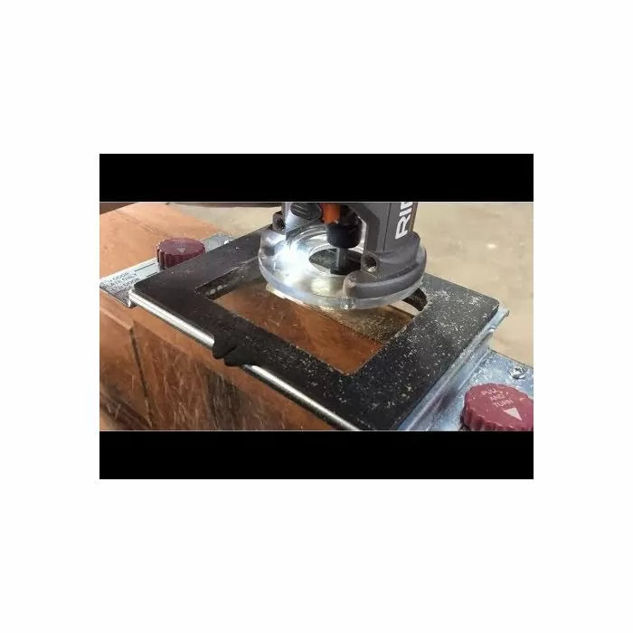 Woodworking router cutting wood with guide jig on workbench