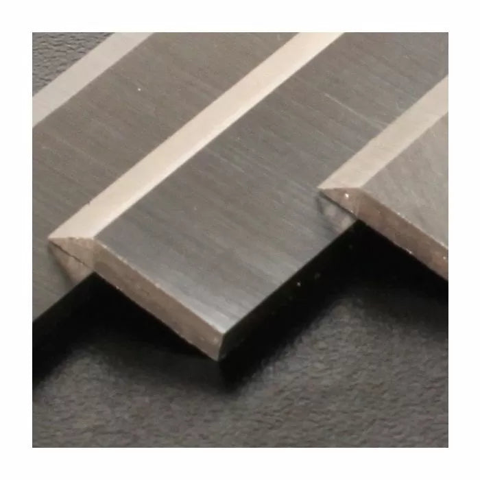Close-up of carbide woodworking planer blades, showing sharp metal cutting edges.