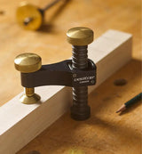 Veritas woodworking clamp on a workbench clamping a wooden board, precision tool