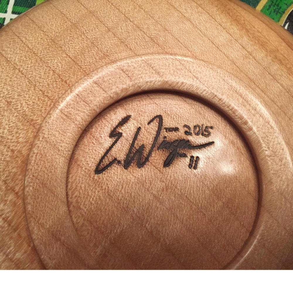 Close-up of a signed wooden bowl base, showcasing fine woodworking craftsmanship.
