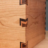 Close-up of a wooden box corner with decorative inlaid dovetail joints for woodworking