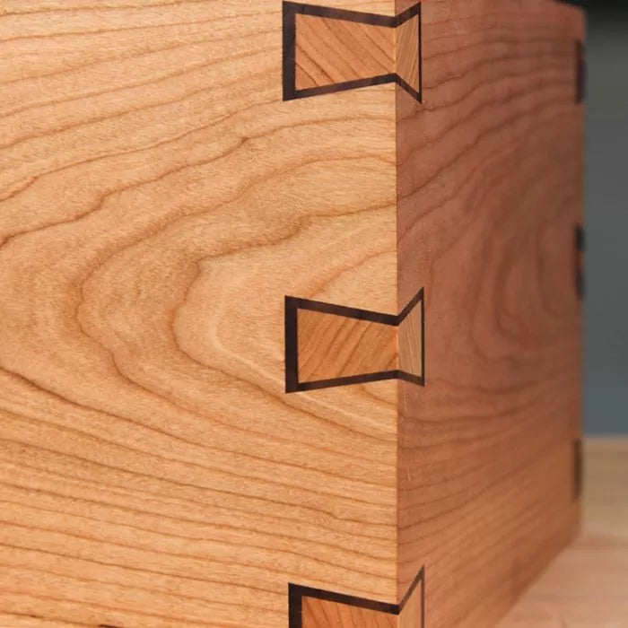 Close-up of a wooden box corner with decorative butterfly inlay joinery for woodworking projects.