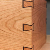 Close-up of a wooden box corner with decorative butterfly inlay joinery for woodworking projects.