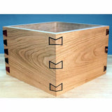 Wooden box with decorative dovetail joinery on a workbench, ideal for woodworking projects.