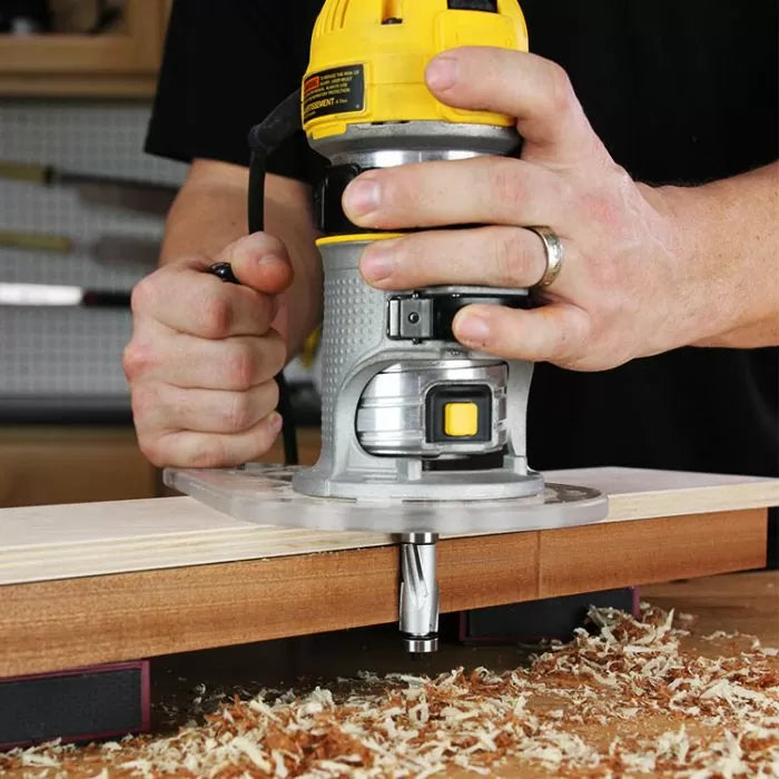 Handheld router shaping wood edge with router bit, woodworking tools in use