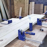 Parallel clamps securing wood boards on a workbench in a woodworking shop