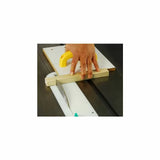 Woodworker using a table saw sled to cut wood with push handle for safety