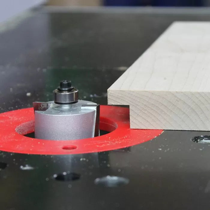 Rabbet router bit installed in router table cutting a groove in a wooden board