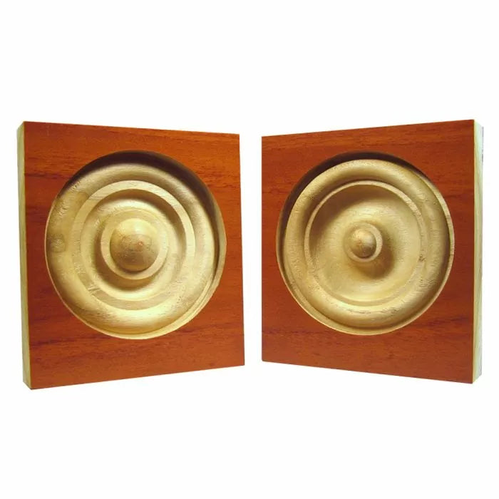 Wooden rosette blocks with concentric carved circles for decorative woodworking.