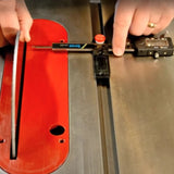 Digital caliper measuring saw blade alignment on a table saw with red insert closeup