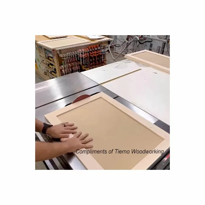 Woodworker assembling a cabinet door frame on a woodworking table with clamps in workshop