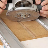 Woodworker using a straight router bit to cut a groove in a wooden board with guides