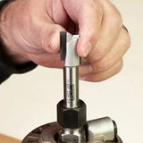 Hand installing a straight router bit into a router collet, woodworking tool closeup.