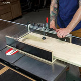 Woodworker using a table saw crosscut sled to cut a wooden board in a workshop