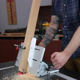 Person using a table saw jig to cut a wooden board in a woodworking shop