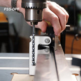 Drill press fence stop attachment with drill bit on a woodworking table